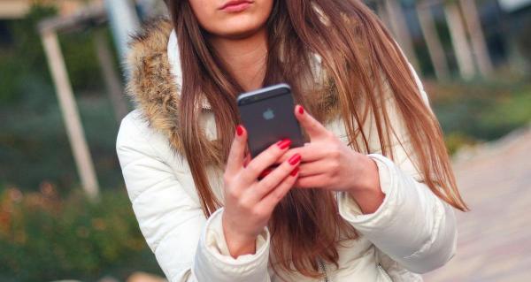 Femeie se uită la un telefon