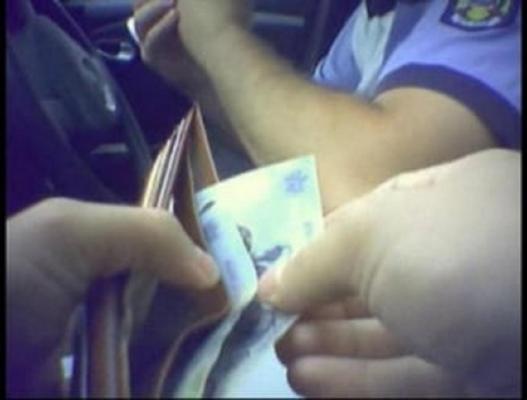 Doi tineri din Suceava au încercat să oblige un polițist să ia mită, îndesându-i cu forța în buzunare 100 de euro