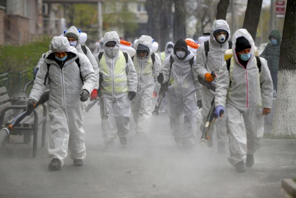 Angajati ai primariei sectorului 6 atomizeaza dezinfectant pe trotuar si in spatiile adiacente Bulevardului Iuliu Maniu din Bucuresti, in timpul unei campanii de dezinfectare pentru a stopa raspandirea COVID-19, marti, 31 martie 2020