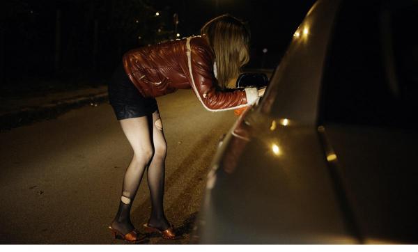 Femeie îmbrăcată sumar lângă geamul unei maşini