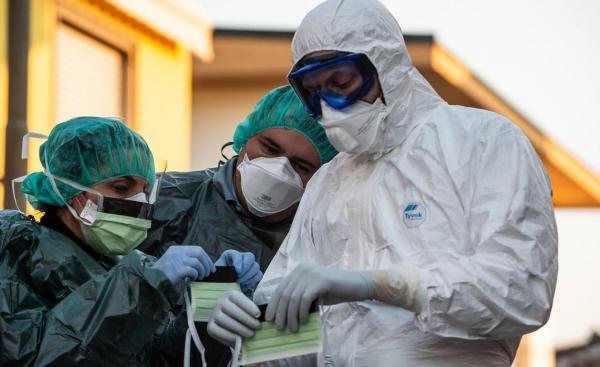 Medici în costume de protecție verifică dacă sunt cazuri de coronavirus