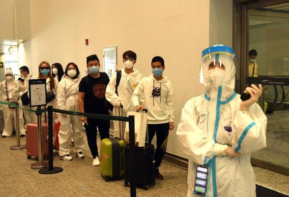 Persoane așteaptă la coadă, în aeroport