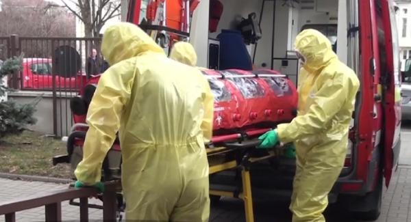 Medici în combinezoane transportă un caz de coronavirus cu izoleta