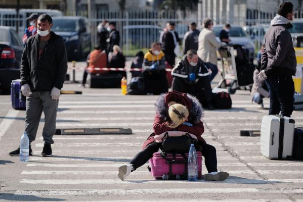 Muncitori români care așteaptă pe aeroportul din Cluj să poată pleca spre Germania