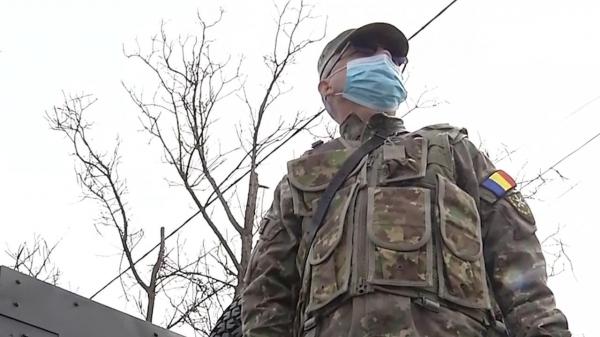 Militar român poartă mască de protecție