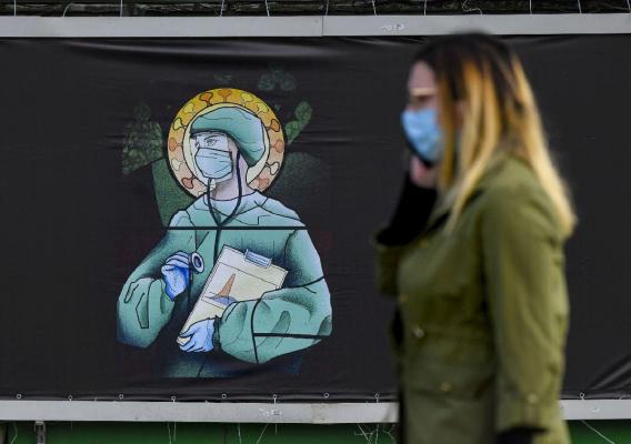 O femeie trece pe langa un panou publicitar