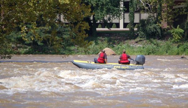 Imagine reprezentativă cu o echipă de salvatori căutând cu barca pe râu