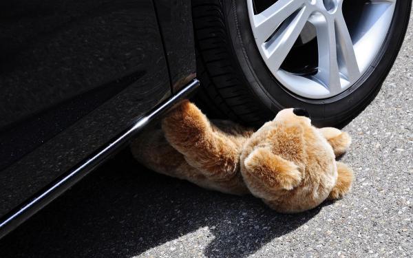 Ursuleţ de pluş lângă roata unei maşini