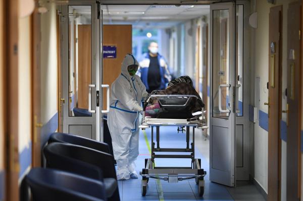 Pacient dus pe targă în spital de un medic echipat complet împotriva Covid-19