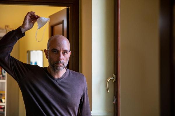 Un bărbat își dă masca jos, în locuință