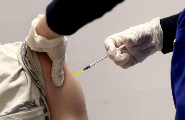 O persoană este vaccinată cu vaccinul împotriva Covid-19