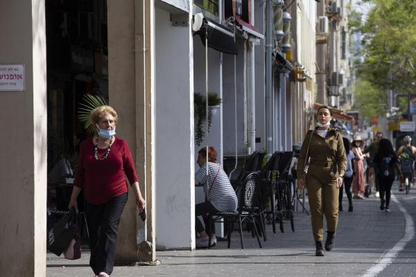 Oamenii fără măști de protecție merg pe o stradă, din Tel Aviv, Israel