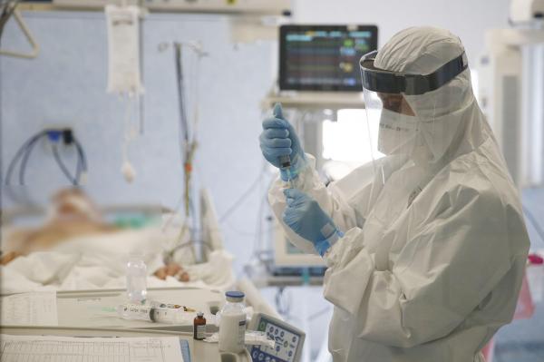 Un medic asistă un pacient care suferă de complicații după infecția cu coronavirus (Covid-19)