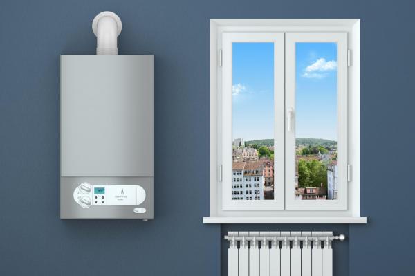 O centrală de apartament pe gaz, pusă pe un perete pe care este o fereastră