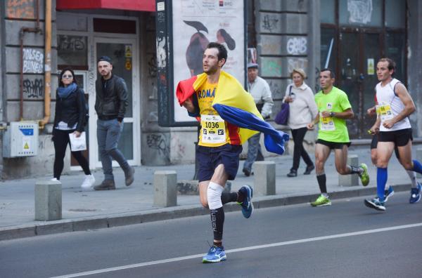 Alergător cu steagul României în timpul Maratonului Bucureşti din 2017