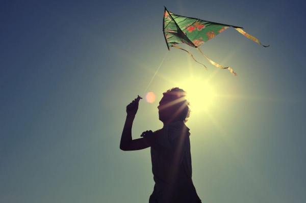 silueta unui copil care ține un zmeu