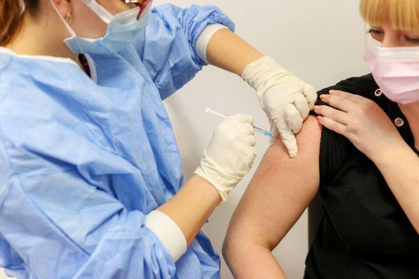 O femeie primeste vaccinul împotriva Covid-19