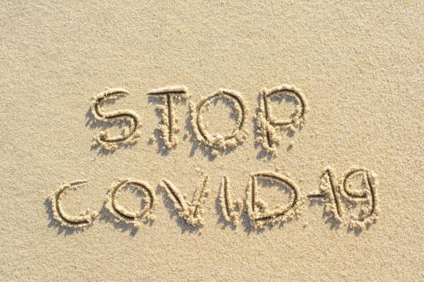 Mesaj Stop Covid-19 scris pe nisip