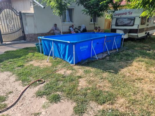 Locuitorii dintr-un sat din Timiş, inventivi şi economi: Şi-au scos piscinele în faţa caselor şi le-au umplut cu apă de la cişmeaua publică
