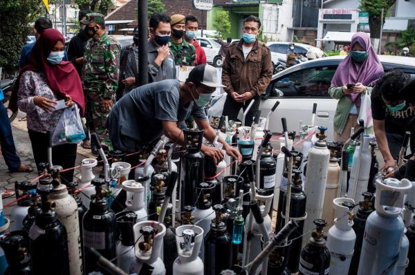Oamenii stau la coadă pentru a-și umple tuburile de oxigen în Yogyakarta, Indonezia, 14 iulie 2021