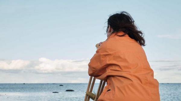 Femeie cu spatele privind spre mare