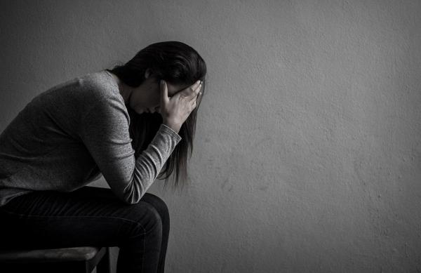 Femeie cu faţa în palpe, privind spre podea