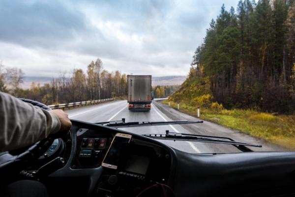Bărbat la volanul unui camion, pe șosea