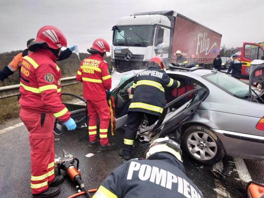 BMW zdrobit de TIR, pe un drum din Caraș-Severin. Șoferul mașinii și-a văzut soția sfârșind sub ochii lui