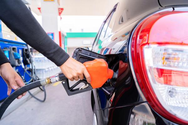 Un bărbat alimentează cu carburant maşina