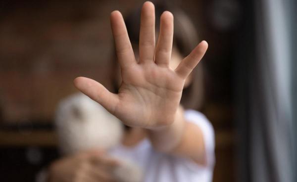 Fetiţă cu palma îndreptată înainte, fundal blurat