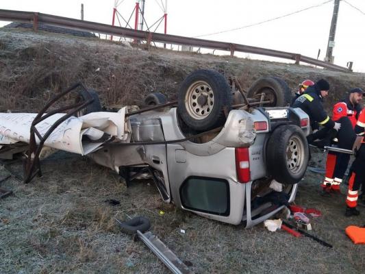 Femeie, salvată de sub fiarele maşinii de un pompier aflat în timpul liber. Şoferiţa se răsturnase cu maşina pe un câmp din Bihor