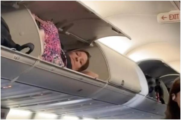 Americancă filmată în timp ce trăgea un pui de somn în spațiul de depozitare a bagajelor din avion. "Cum a ajuns acolo?"