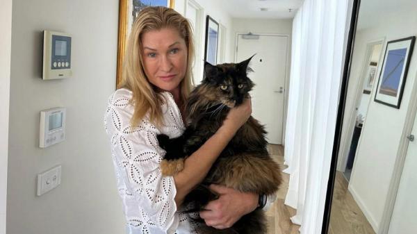 Mittens, alături de stăpâna sa. Pisica a fost uitată în avion şi a călătorit de trei ori între Noua Zeelandă și Australia în 24 de ore