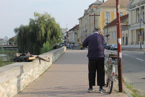 bătrân cu bicicleta într-un oraş din România