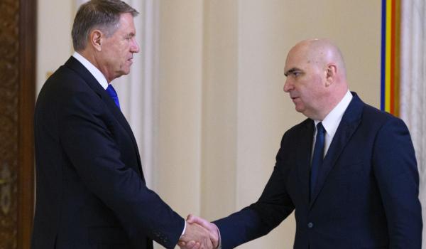 Presedintele Klaus Iohannis il saluta pe Ilie Bolojan, liderul PNL, inaintea desemnarii lui lui Marcel Ciolacu (nu se afla in imagine) pentru pozitia de prim-ministru, luni, 23 decembrie 2024, la Palatul Cotroceni din Bucuresti.