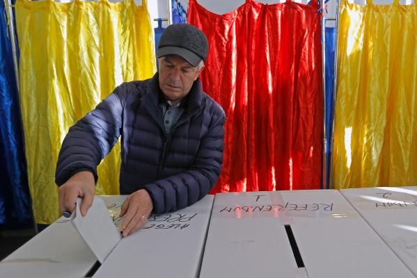 Un bărbat votează în timpul primului tur al alegerilor prezidențiale la o secție de votare din București, România, 24 noiembrie 2024