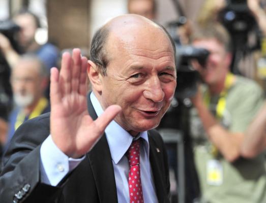 Președintele României, Traian Băsescu, salută în timp ce sosește la o reuniune specială a Consiliului European pentru a discuta despre numirile ulterioare la sediul Uniunii Europene din Bruxelles, pe 16 iulie 2014