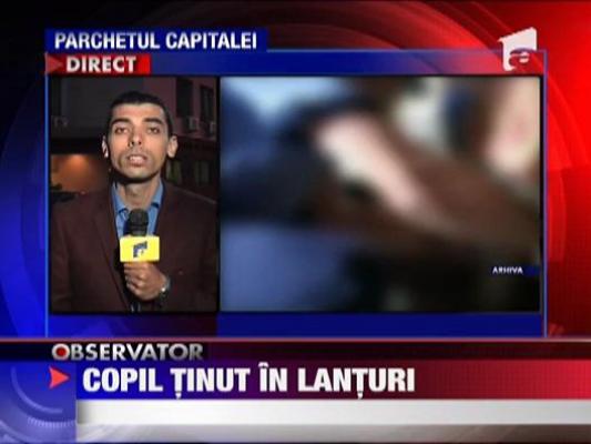 Copil tinut in lanturi