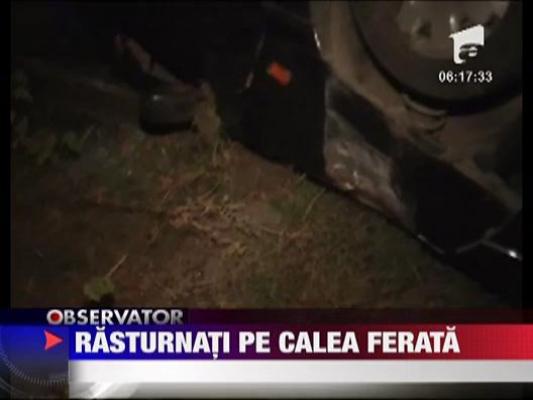 S-a rasturnat cu masina pe calea ferata