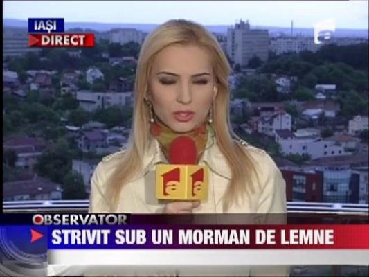 Tanar strivit sub un morman de lemne