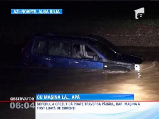 Un sofer din Alba Iulia a ramas cu masina in mijlocul unui parau umflat