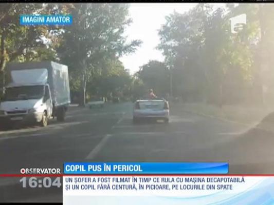 Inconştienţă la volan. Un şofer a fost filmat în timp ce rula cu maşina decapotabilă şi un copil fără centruă