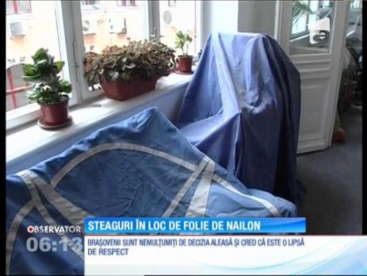 Steagurile României, NATO şi UE, folosite pe post de nailon de muncitorii care renovează sediul CJ din Braşov