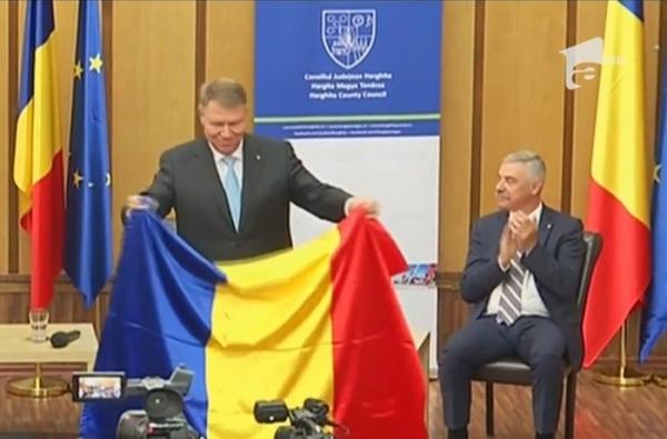 În prima vizită oficială în Harghita şi Covasna, Klaus Iohannis a primit în dar drapelul secuiesc. Reacţia preşedintelui a devenit virală