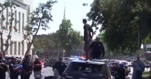 Imagini incredibile filmate în Statele Unite. Un tânăr s-a urcat pe coperişul unei maşini de poliţie şi a început să sară, de faţă cu agenţii