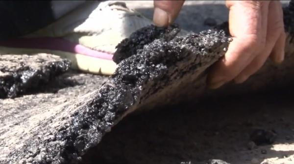 Asfalt abia turnat, smuls cu mâna de pe drum, în Vatra Dornei