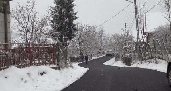 Mai mulţi muncitori toarnă asfalt pe o stradă din Bistriţa Năsăud, în plină ninsoare (Video)