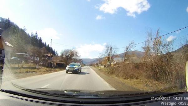 Momentul în care o maşină de poliţie face o depăşire periculoasă pe un drum din Neamţ. Imaginile au fost surprinse de către un alt şofer