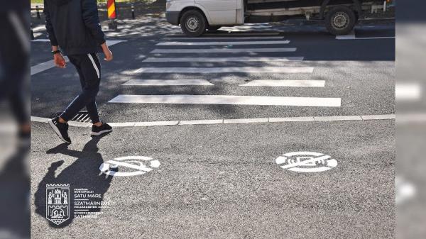 Soluția primăriei Satu Mare pentru a reduce numărul de accidente. Pietonii, atenționați prin marcaje speciale să nu folosească telefonul sau căștile când traversează