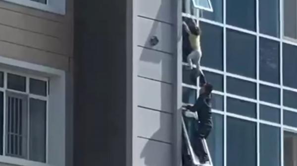 O fetiţă de trei ani care atârna de la fereastră, salvată în ultimul moment de un bărbat din Kazahstan
